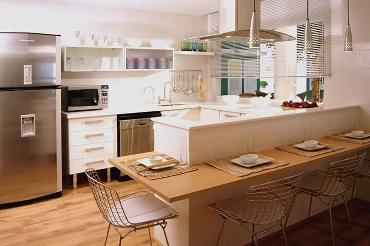 Cozinha planejada com bancada e mesa